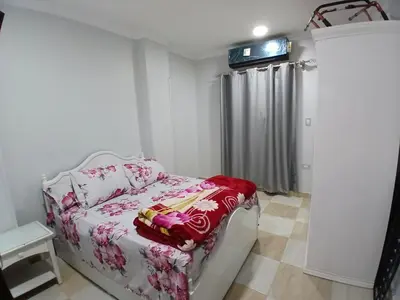 a bedroom with a couch with a red blanket on it at الشيراتون شارع السنترال السياحي in Hurghada