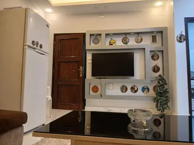 a living room with a flat screen tv and a refrigerator at الشيراتون شارع السنترال السياحي in Hurghada