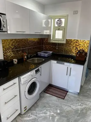 a kitchen with a sink and a washing machine at Niebieski Apartament in Hurghada