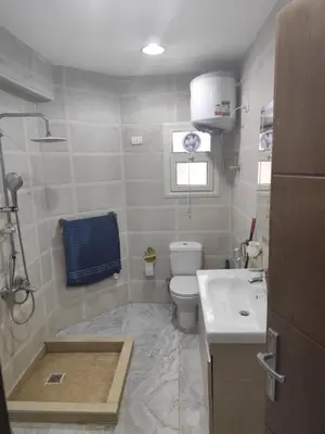 a bathroom with a tub and a toilet and a sink at Niebieski Apartament in Hurghada