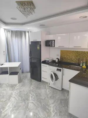 a kitchen with a refrigerator and a washing machine at Niebieski Apartament in Hurghada