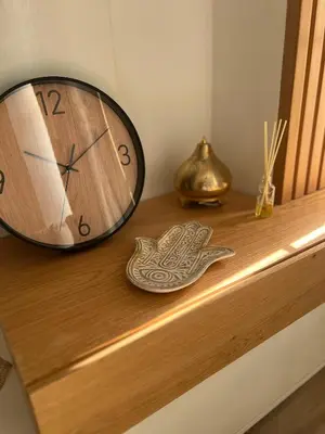 a clock sitting on top of a wooden shelf at Royal Club Residence in Port Ghalib