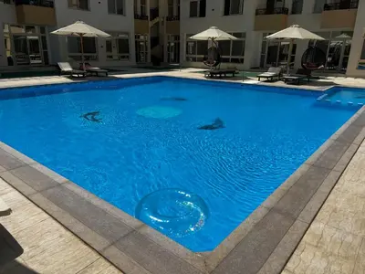 a large blue swimming pool with fish in the water at Royal Club Residence in Port Ghalib
