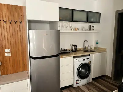 a kitchen with a refrigerator and a washing machine at Royal Club Residence in Port Ghalib