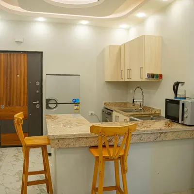a kitchen with a counter and two wooden stools at Two Bedroom Apartment in Hurghada