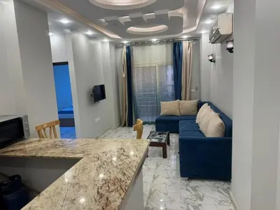 a living room with a couch and a blue couch at Two Bedroom Apartment in Hurghada