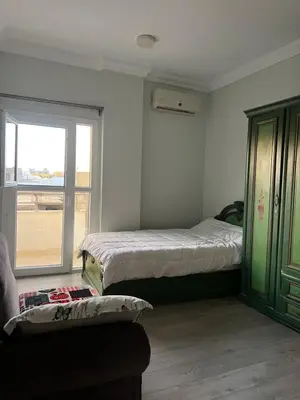a bedroom with two beds and a window and a couch at Poraa roof in Hurghada