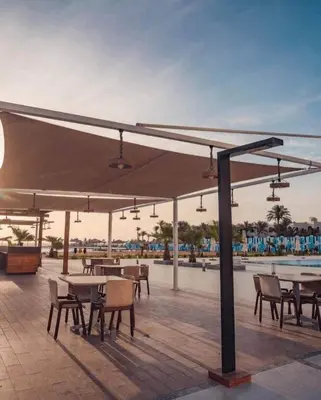 a patio with tables and chairs under a large umbrella at Scandic Resort A531 in Hurghada
