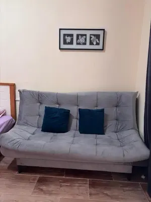 a couch with two blue pillows in a living room at nice apartment in Hurghada