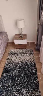 a room with a bed and a table with a rug at Bay View, Sahl Hashish, Hurghada in Hurghada