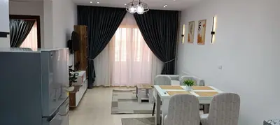a living room with a dining room table and chairs at Bay View, Sahl Hashish, Hurghada in Hurghada