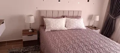 a bedroom with a large bed with two night stands at Bay View, Sahl Hashish, Hurghada in Hurghada