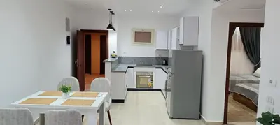 a kitchen and living room with a table and chairs at Bay View, Sahl Hashish, Hurghada in Hurghada