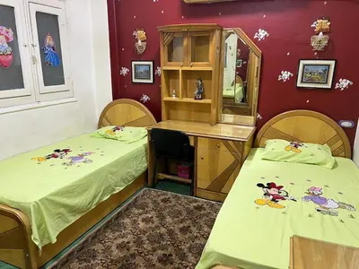 a room with two beds and a vanity with a mirror at Velvet Rose Apartment in Luxor