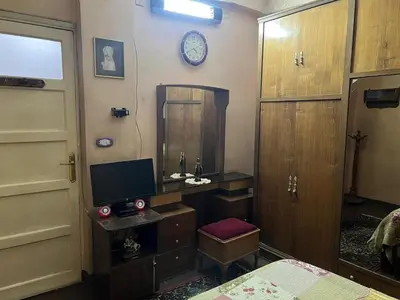 a bedroom with a desk and a mirror and a clock at Velvet Rose Apartment in Luxor