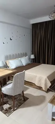 a bedroom with a bed and a table and a chair at Bay View, Sahl Hashish in Hurghada