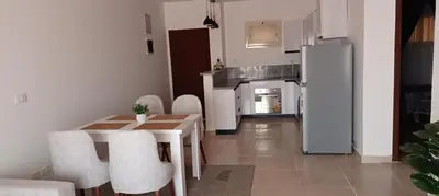 a kitchen with a table and chairs and a refrigerator at 2 bedroom apartment Bay View sahl hasheesh in Hurghada