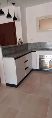 a kitchen with white cabinets and a counter top at 2 bedroom apartment Bay View sahl hasheesh in Hurghada