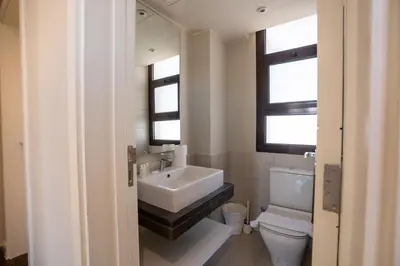 a white bathroom with a sink and a toilet at Chic Cyan 4BR Villa with Private Pool in Hurghada