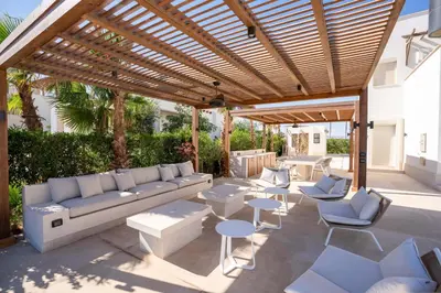 a patio with a couch and tables and a wooden pergola at Chic Cyan 4BR Villa with Private Pool in Hurghada