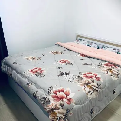 a bed with a floral bedspread on it at Princess resort Hurghada in Hurghada