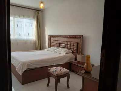 a bedroom with a bed and a chair and a window at Flat 10 minutes from the airport in Hurghada
