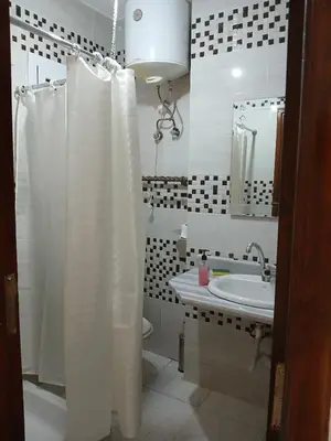 a bathroom with a white shower curtain and a sink at Flat 10 minutes from the airport in Hurghada