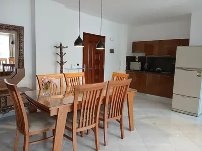 a kitchen and dining room with a wooden table and chairs at Flat 10 minutes from the airport in Hurghada