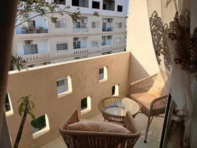 a balcony with a table and chairs and a building at Flat 10 minutes from the airport in Hurghada