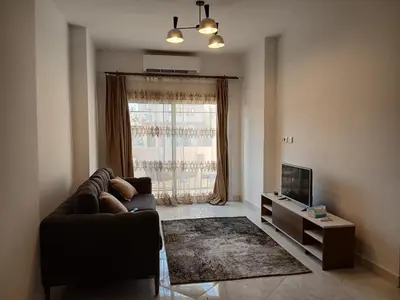 a living room with a couch and a television at Flat 10 minutes from the airport in Hurghada