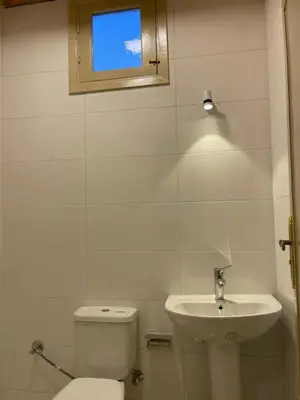 a white bathroom with a toilet and a sink at in luxor apartment in Luxor