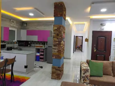 a kitchen and living room with a couch and a table at Apartment in villa in Magawish in Hurghada
