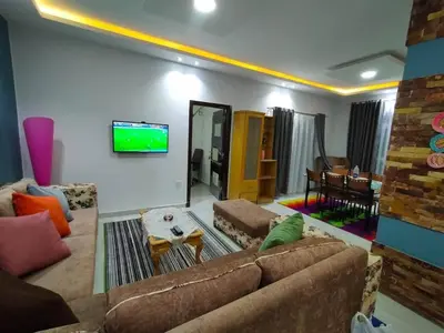 a living room with a couch and a flat screen tv at Apartment in villa in Magawish in Hurghada