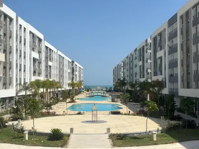 a view of a large apartment complex with a swimming pool at Fanadir Bay Resort Canary Apartman in Hurghada