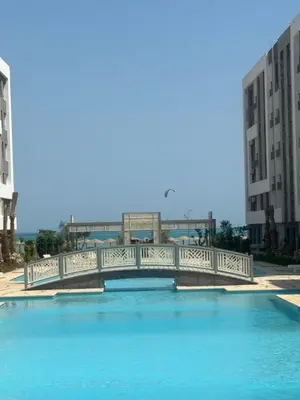 a bridge over a large pool of water with buildings at Fanadir Bay Resort Canary Apartman in Hurghada