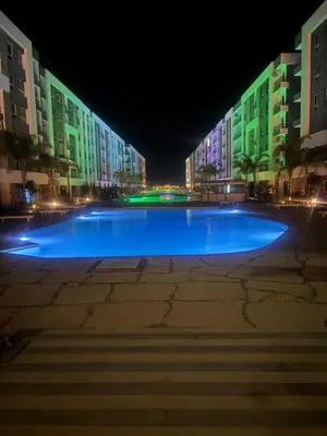 a large pool of blue water in front of a building at Fanadir Bay Resort Canary Apartman in Hurghada