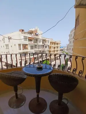 a table and chairs on a balcony with buildings at شقه مميزه في عرابيا الغردقه امام فندق بيروت in Hurghada