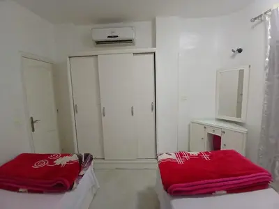 a bedroom with white cabinets and a red blanket at شقه مميزه في عرابيا الغردقه امام فندق بيروت in Hurghada