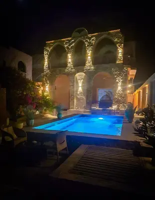 a swimming pool in a yard at night at FairHaven Apartments in Luxor