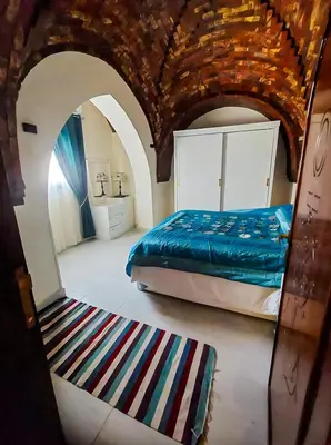 a bedroom with a king sized bed and a rug at FairHaven Apartments in Luxor