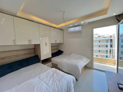 a bedroom with two beds and a large window at Hurghada Hub Resort in Hurghada
