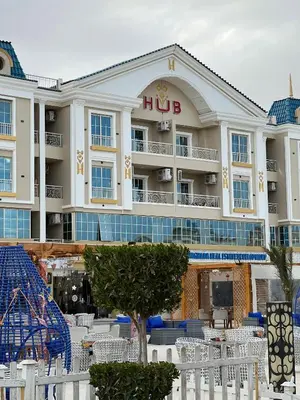 a hotel with white tables and chairs in front of it at Hurghada Hub Resort in Hurghada