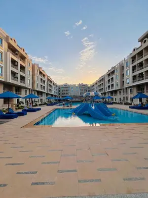 a swimming pool in the middle of a apartment complex at Hurghada Hub Resort in Hurghada