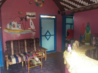 a room with a bedroom with a bed and a door at Shamandora Nubian Guest House in Jazīrat Fīlah