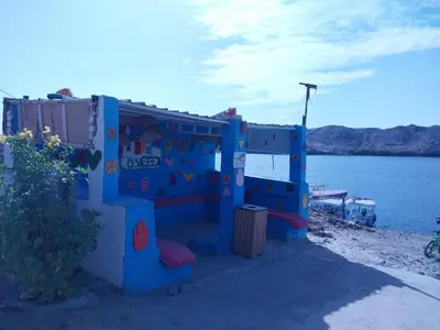 a blue play house next to a body of water at Shamandora Nubian Guest House in Jazīrat Fīlah