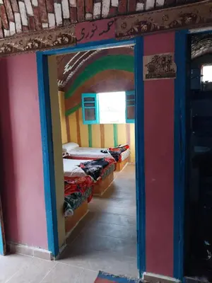 a room with a room with four beds in it at Shamandora Nubian Guest House in Jazīrat Fīlah