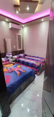 two beds in a room with purple lights at الغردقة شارع مترو in Hurghada