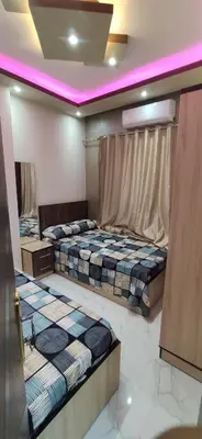 two beds in a room with purple lighting at الغردقة شارع مترو in Hurghada
