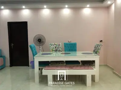 a white table with chairs and a fan in a room at Paradise Gates Hurghada in Hurghada