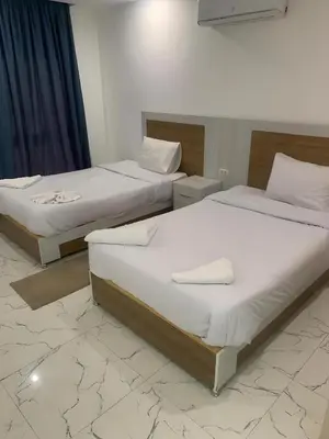 two beds in a hotel room with white sheets at Fanadir Bay Premier all inclusive resort in Hurghada